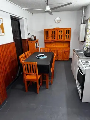 a kitchen with a table and some wooden cabinets at Casa pleno centro Villa Dolores in Villa Dolores