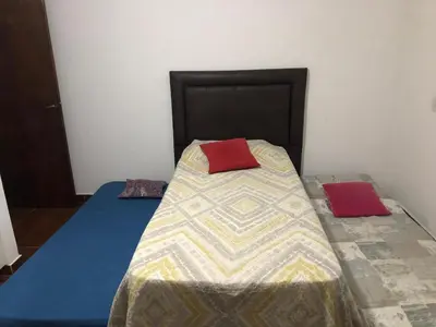 a bed with two red pillows on top of it at Casa- alojamiento Gerez in San Antonio de Arredondo
