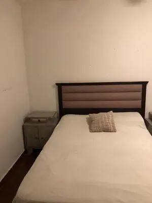 a bed with a wooden headboard and a pillow on it at Casa- alojamiento Gerez in San Antonio de Arredondo