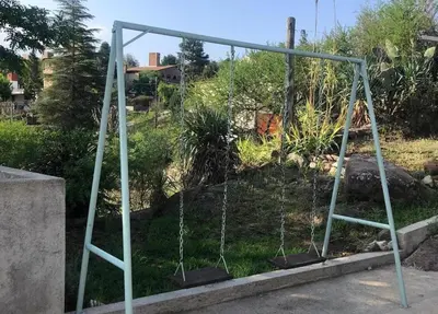an empty swing set in a garden at Casa- alojamiento Gerez in San Antonio de Arredondo