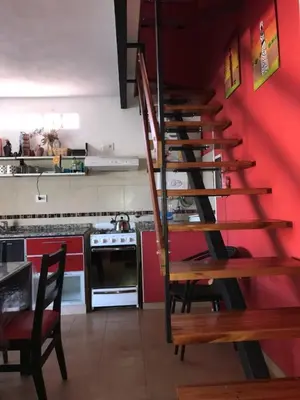 a staircase in a kitchen with a red wall at Complejo Soles de Oro in Villa Icho Cruz