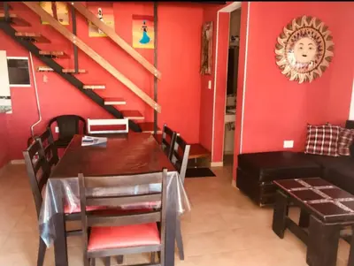 a dining room with a table and a red wall at Complejo Soles de Oro in Villa Icho Cruz