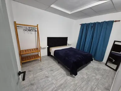 a bedroom with a bed and a mirror and blue curtains at Colibri 3 in Merlo