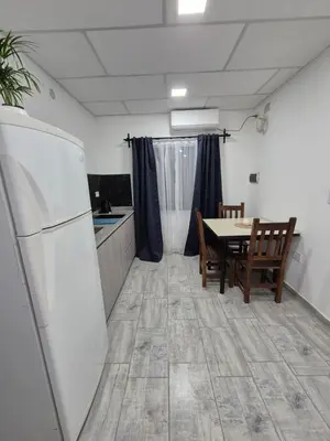 a kitchen with a table and a white refrigerator at Colibri 3 in Merlo