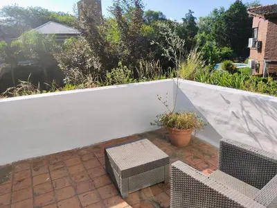 a patio with a white fence and a bench at Casa Mudita in Cordoba