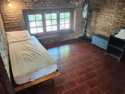a bedroom with a bed and a brick wall at Casa Mudita in Cordoba