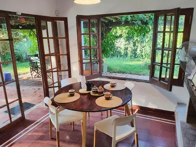a dining room with a table and chairs and windows at Casa Mudita in Cordoba