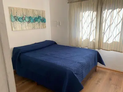 a bedroom with a blue bed and a window at San Plácido in Bialet Massé