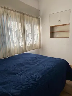 a bedroom with a blue bed and a window at San Plácido in Bialet Massé