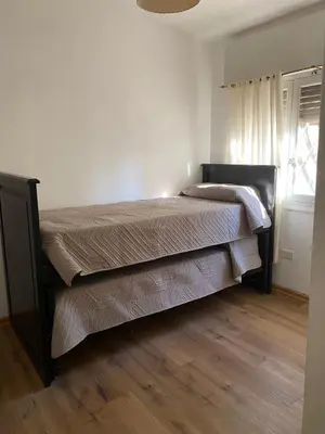 a bed in a bedroom with a wooden floor at San Plácido in Bialet Massé