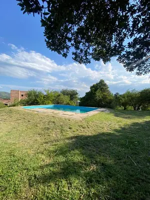 a blue swimming pool in a grass field at San Plácido in Bialet Massé
