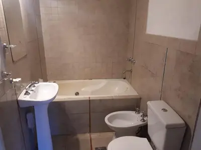 a bathroom with a toilet and a tub and a sink at Dúplex el descanso in Villa Anizacate