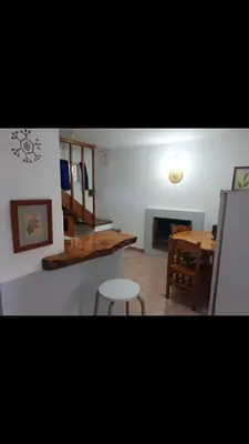 a living room with a table and a table and a chair at Dúplex el descanso in Villa Anizacate