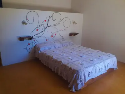 a bedroom with a bed with a flower mural on the wall at Dúplex el descanso in Villa Anizacate