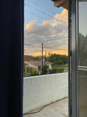 an open window with a view of a house at Depto Dos Plantas en Bialet Massé in Bialet Massé