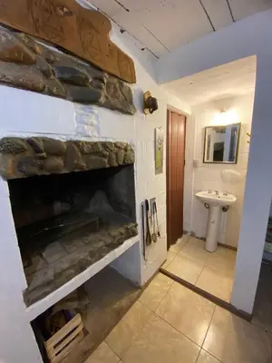 a stone fireplace in a bathroom with a sink at Depto Dos Plantas en Bialet Massé in Bialet Massé