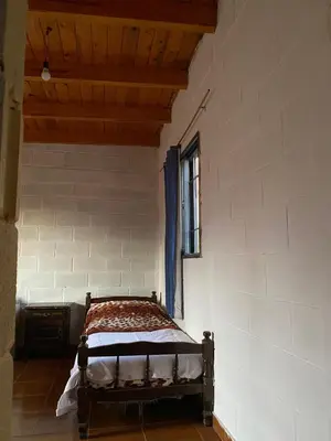 a bedroom with a bed in a room with a window at Depto Dos Plantas en Bialet Massé in Bialet Massé