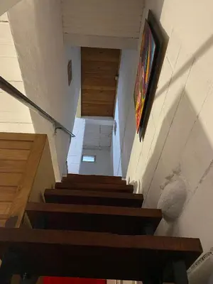 a stairway with wooden steps and a painting on the wall at Depto Dos Plantas en Bialet Massé in Bialet Massé