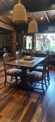 a wooden table with two chairs and a dining room at Cabaña tierra de sueños in Santa Rosa de Calamuchita