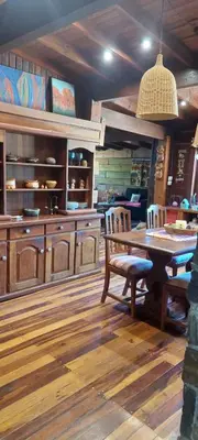 a kitchen with a wooden table and a dining room at Cabaña tierra de sueños in Santa Rosa de Calamuchita