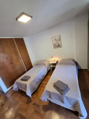 two beds in a room with wooden floors at Cómodo departamento en Nueva Córdoba in Cordoba