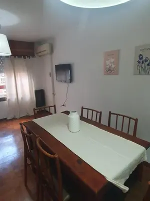 a dining room table with a white table cloth on it at Cómodo departamento en Nueva Córdoba in Cordoba