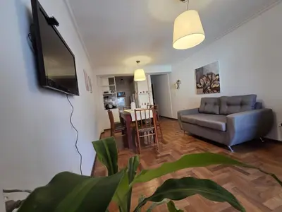a living room with a couch and a television and a table at Cómodo departamento en Nueva Córdoba in Cordoba