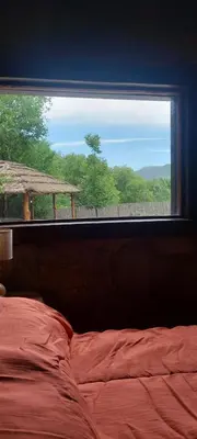 a bedroom with a window with a bed and a view at Tierra de Sueños in Santa Rosa de Calamuchita