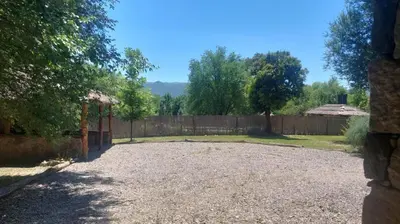 a backyard with a fence and a gravel driveway at Tierra de Sueños in Santa Rosa de Calamuchita