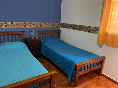 two twin beds in a room with blue walls at La soñada San Antonio de Arredondo in San Antonio de Arredondo