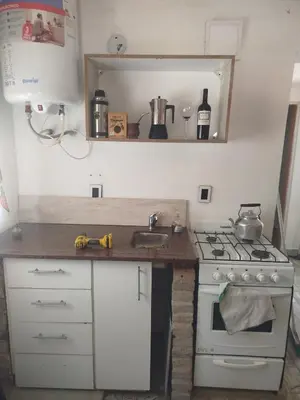 a kitchen with a stove and a sink and a counter at Cabaña rio de los sauces in Río de los Sauces