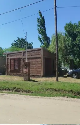 a small wooden house on the side of a road at Cabaña rio de los sauces in Río de los Sauces