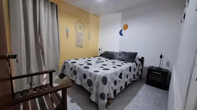 a bedroom with a bed with a black and white comforter at La Gringa House in Cordoba