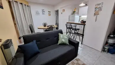 a living room with a couch and a kitchen at La Gringa House in Cordoba