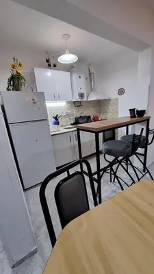 a kitchen with a table and chairs and a refrigerator at La Gringa House in Cordoba