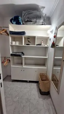 a walk in closet with white shelves and a mirror at La Gringa House in Cordoba