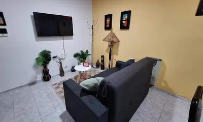 a living room with a couch and a flat screen tv at La Gringa House in Cordoba