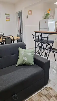 a couch with a green pillow on it in a living room at La Gringa House in Cordoba