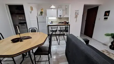 a living room and kitchen with a table and chairs at La Gringa House in Cordoba