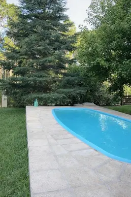 a swimming pool in a yard with a stone walkway at El Bosque de Simba - Cabaña in La Estancia