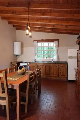 a kitchen with a wooden table and a window at El Bosque de Simba - Cabaña in La Estancia