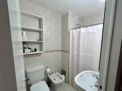 a white bathroom with a toilet and a sink at Departamento amplio 3 personas Zona Nueva Córdoba in Cordoba