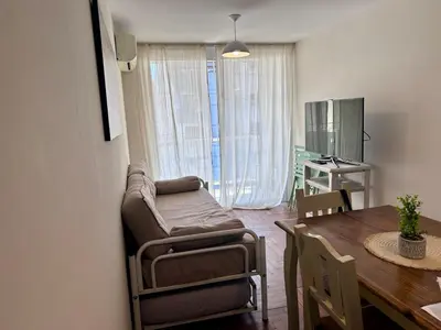a living room with a chair and a dining room table at Departamento amplio 3 personas Zona Nueva Córdoba in Cordoba