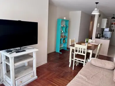 a living room with a flat screen tv and a table at Departamento amplio 3 personas Zona Nueva Córdoba in Cordoba
