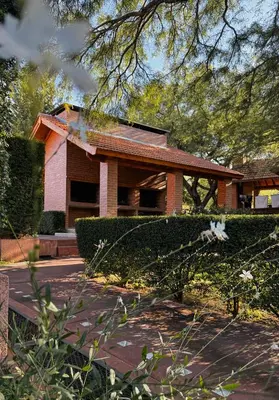 a house with a hedge in front of it at Complejo Udacha - APART in Carpintería