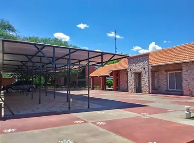 a large metal pavilion in front of a building at Complejo Udacha - APART in Carpintería