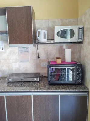 a kitchen counter with a toaster oven and a microwave at Complejo Udacha - APART in Carpintería