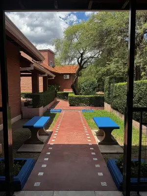 a pathway with two blue benches and a building at Complejo Udacha - APART in Carpintería