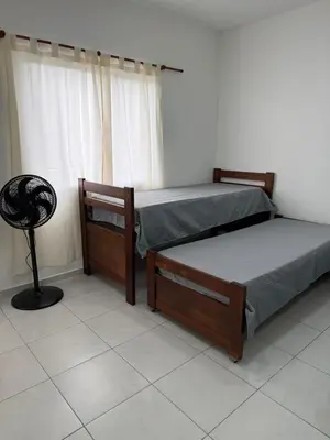 two beds in a room with a window at Departamentos Mi Cielo in Villa Cura Brochero