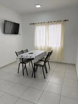a dining room with a table and chairs and a television at Departamentos Mi Cielo in Villa Cura Brochero